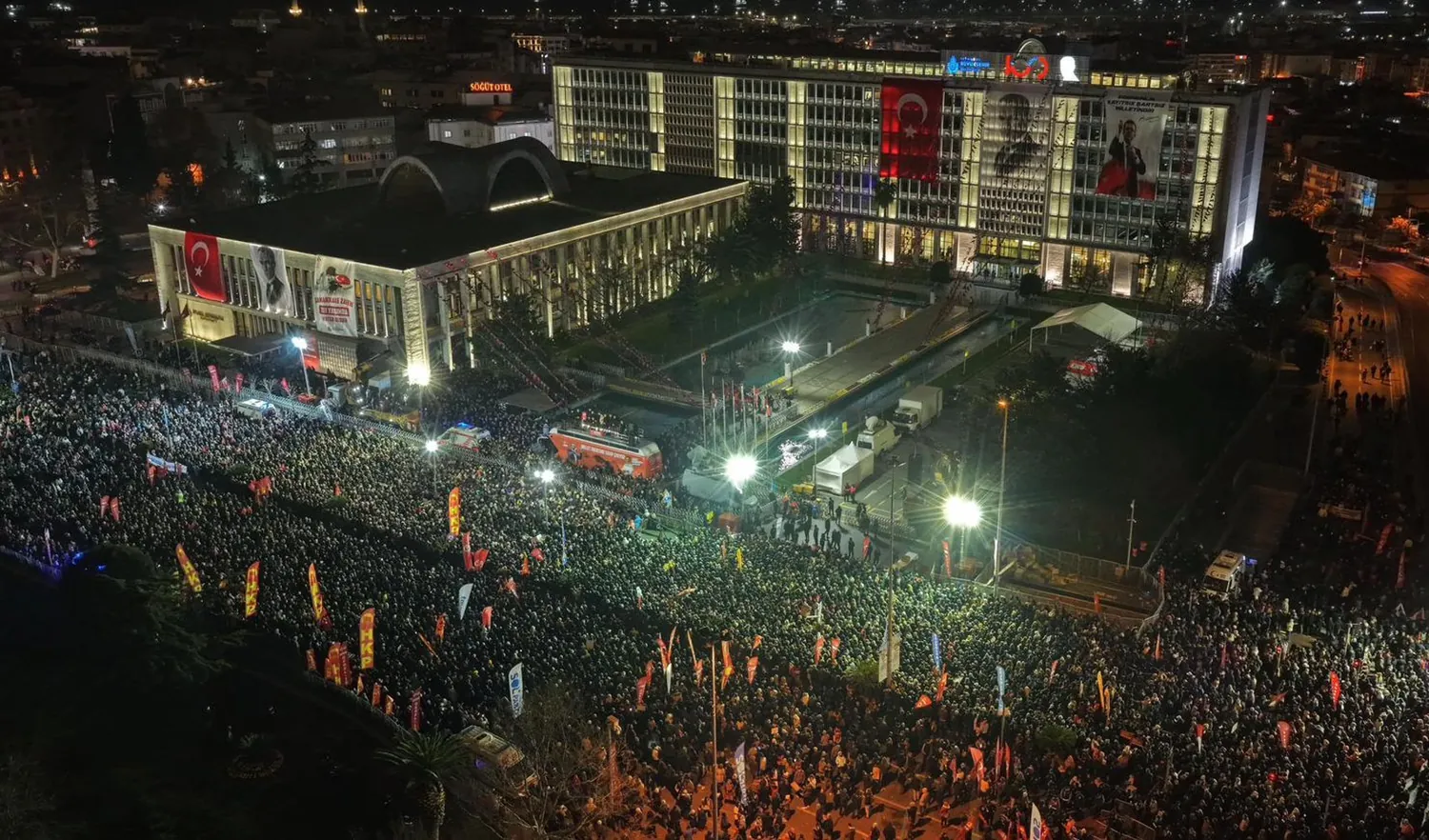 Aerial night view of a massive crowd gathered in front of Istanbul City Hall in Saraçhane.